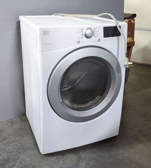 White front-loading washing machine in a home setting, illustrating APEX Appliance Repair services for washer repair and maintenance.